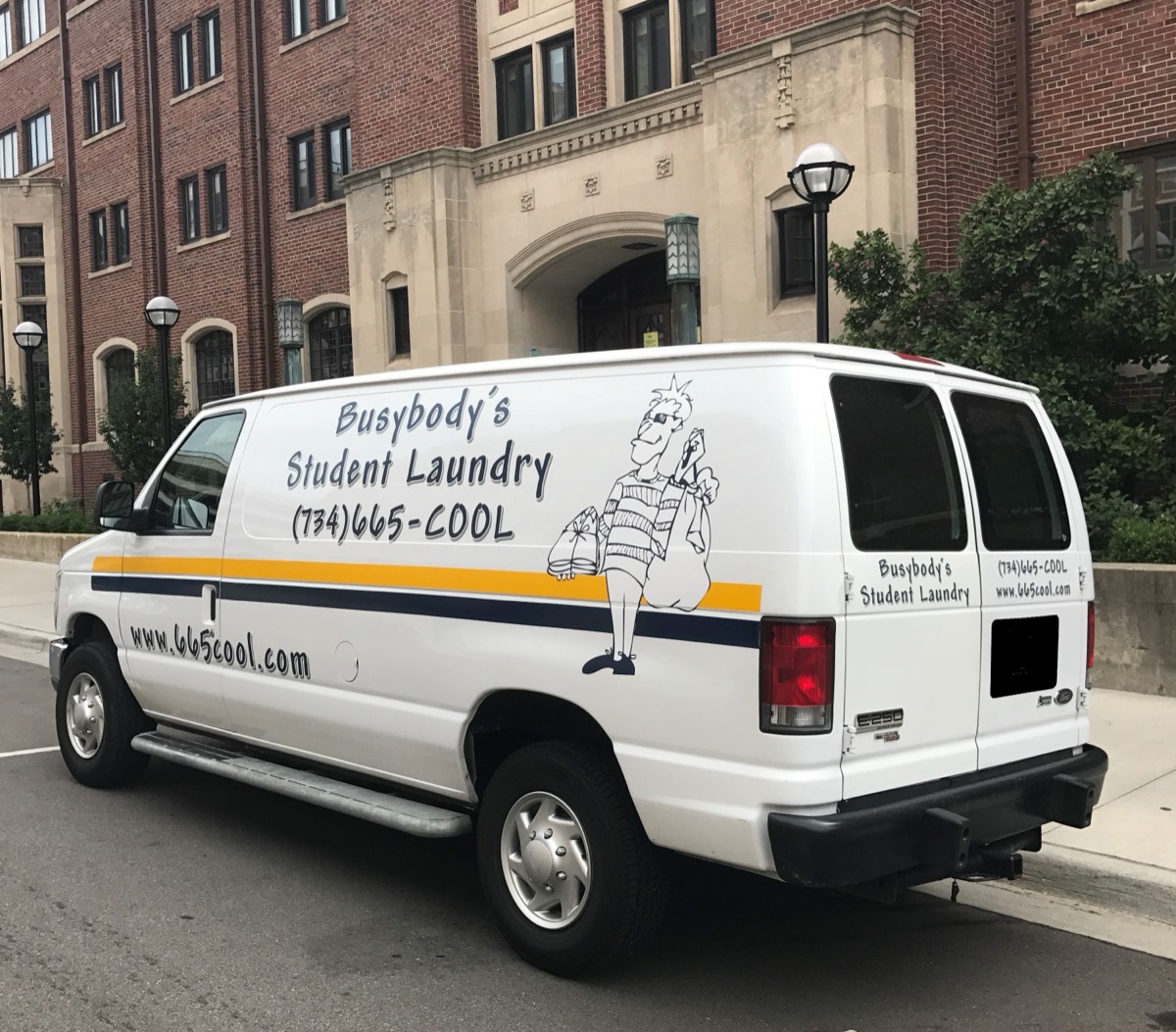 Busybody's branded van parked in front of a University of Michigan building